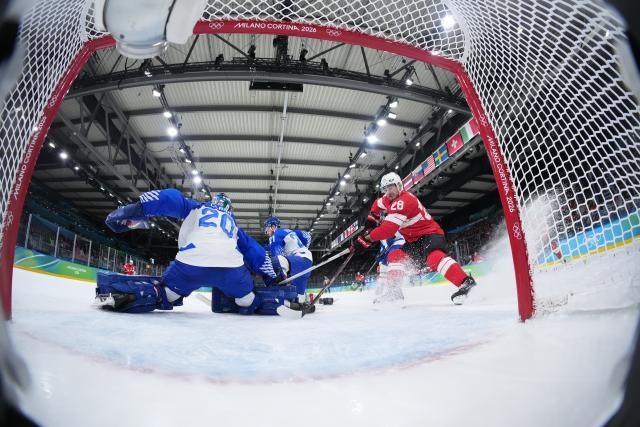 (260217) -- MILANMILAN, Feb. 17, 2026 (Xinhua) -- Timo Meier (R) of Switzerland shoots during the ice hockey men's qualification play-off round match between Switzerland and Italy at the Milan-Cortina 2026 Olympic Winter Games in Milan, Italy, Feb. 17, 2026. (Xinhua/Tao Xiyi)