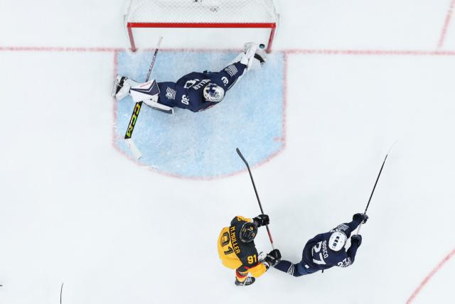 (260217) -- MILAN, Feb. 17, 2026 (Xinhua) -- Goalkeeper Antoine Keller (top) of France makes a save during the ice hockey men's qualification play-off match between Germany and France at the Milan-Cortina 2026 Olympic Winter Games in Milan, Italy, Feb. 17, 2026. (Xinhua/Wang Kaiyan)