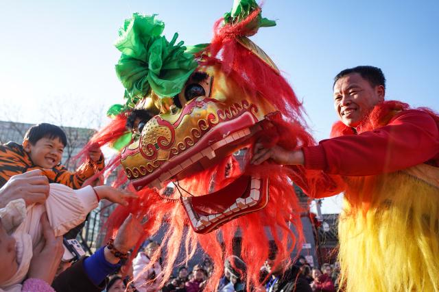 (260217) -- BEIJING, Feb. 17, 2026 (Xinhua) -- People interact with a lion dance performer at a temple fair in Beijing, capital of China, Feb. 17, 2026. Temple fairs opened here celebrating the Spring Festival and presenting visitors with traditional dances, lion dances and delicious food. (Xinhua/Chen Zhonghao)