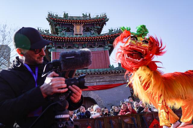 (260217) -- BEIJING, Feb. 17, 2026 (Xinhua) -- A foreigner films the lion dance performance at a temple fair in Beijing, capital of China, Feb. 17, 2026. Temple fairs opened here celebrating the Spring Festival and presenting visitors with traditional dances, lion dances and delicious food. (Xinhua/Chen Zhonghao)