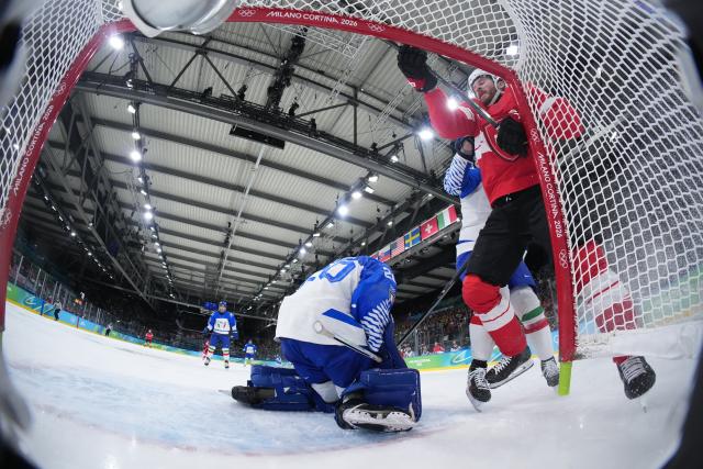 (260217) -- MILAN, Feb. 17, 2026 (Xinhua) -- Christoph Bertschy (1st R) of Switzerland crashes into the goal as he vies for the puck during the ice hockey men's qualification play-off round match between Switzerland and Italy at the Milan-Cortina 2026 Olympic Winter Games in Milan, Italy, Feb. 17, 2026. (Xinhua/Tao Xiyi)