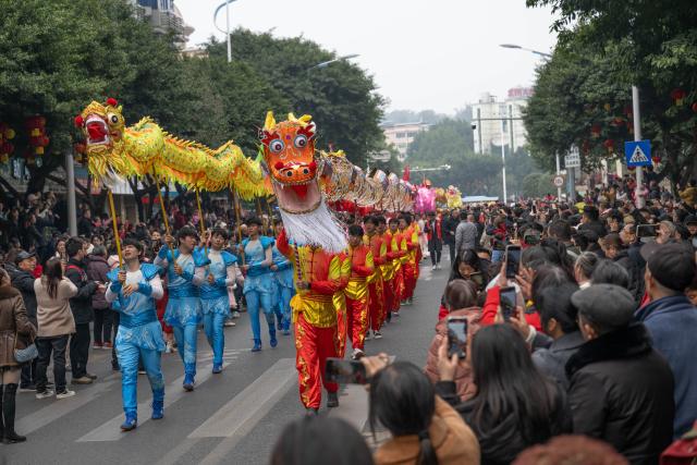 (260217) -- CHONGQING, Feb. 17, 2026 (Xinhua) -- People watch a dragon dance parade held on the streets to celebrate the Chinese New Year in Tongliang District of southwest China's Chongqing Municipality on Feb. 17, 2026. (Xinhua/Chen Cheng)