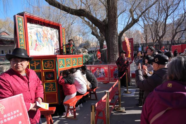 (260217) -- BEIJING, Feb. 17, 2026 (Xinhua) -- People watch a folk performance at a temple fair in Beijing, capital of China, Feb. 17, 2026. This year's Spring Festival saw a surge of visitors eager to experience local cuisine, rich history and vibrant folk performances. (Xinhua/Xie Han)
