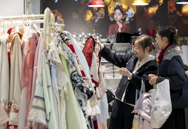 (260217) -- FUZHOU, Feb. 17, 2026 (Xinhua) -- Visitors choose traditional costumes for souvenir photos at Sanfangqixiang (Three Lanes and Seven Alleys) area on the first day of the Chinese New Year in Fuzhou, southeast China's Fujian Province, Feb. 17, 2026. (Xinhua/Wei Peiquan)
