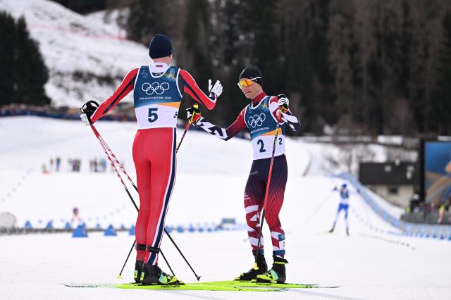 (260217) -- TESERO, Feb. 17, 2026 (Xinhua) -- Jens Luraas Oftebro (L) of Norway greets Johannes Lamparter of Austria after the cross-country event of Nordic Combined Individual Gundersen Large Hill/10km at the Milan-Cortina 2026 Olympic Winter Games in Tesero, Italy, Feb. 17, 2026. (Xinhua/He Canling)
