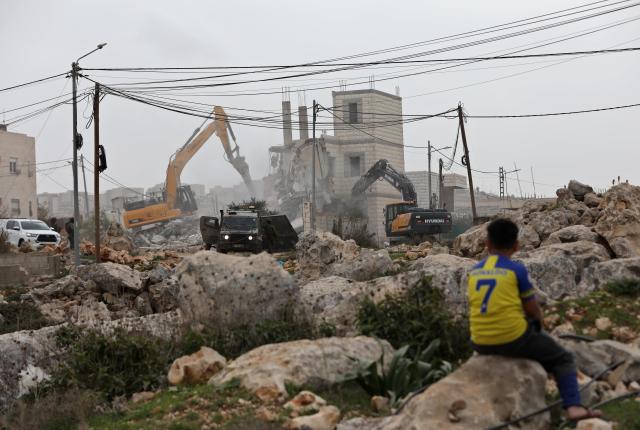 (260217) -- NABLUS, Feb. 17, 2026 (Xinhua) -- Members of Israeli forces stand guard as Israeli excavators demolish a house in Nablus in the northern West Bank, on Feb. 17, 2026. (Photo by Ayman Nobani/Xinhua)