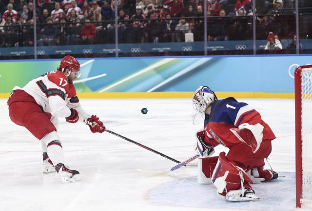 (260217) -- MILAN, Feb. 17, 2026 (Xinhua) -- Nicklas Jensen (L) of Denmark shoots during the ice hockey men's qualification play-off match between the Czech Republic and Denmark at the Milan-Cortina 2026 Olympic Winter Games in Milan, Italy, Feb. 17, 2026. (Xinhua/Wang Kaiyan)