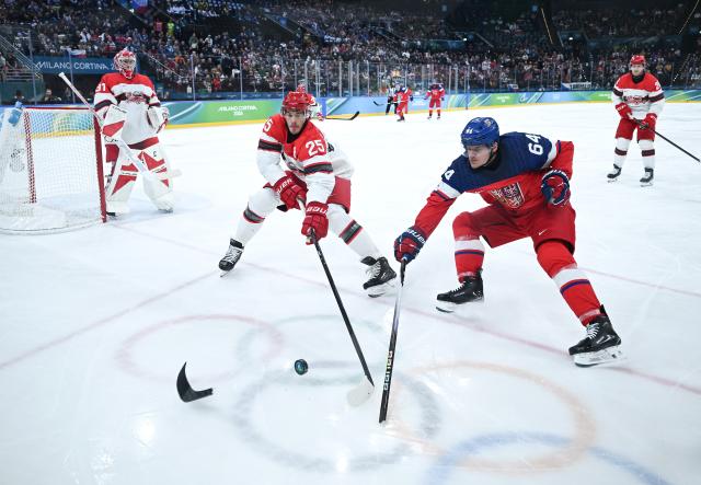 (260217) -- MILAN, Feb. 17, 2026 (Xinhua) -- Oliver Lauridsen (L, front) vies with David Kampf of the Czech Republic during the ice hockey men's qualification play-off match between the Czech Republic and Denmark at the Milan-Cortina 2026 Olympic Winter Games in Milan, Italy, Feb. 17, 2026. (Xinhua/Zhang Haofu)