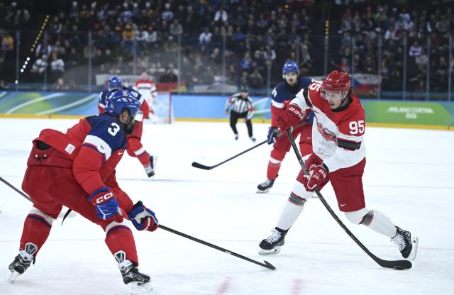 (260217) -- MILAN, Feb. 17, 2026 (Xinhua) -- Nick Olesen (C) of Denmark breaks through during the ice hockey men's qualification play-off match between the Czech Republic and Denmark at the Milan-Cortina 2026 Olympic Winter Games in Milan, Italy, Feb. 17, 2026. (Xinhua/Zhang Haofu)