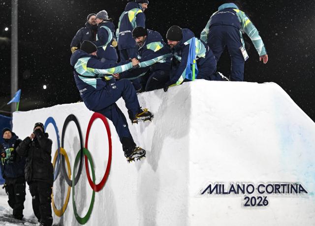 (260218) -- LIVIGNO, Feb. 18, 2026 (Xinhua) -- Staff workers celebrate on the kicker after Freestyle Skiing Men's Freeski Big Air Final at the Milan-Cortina 2026 Olympic Winter Games in Livigno, Italy, Feb. 17, 2026. (Xinhua/Xia Yifang)