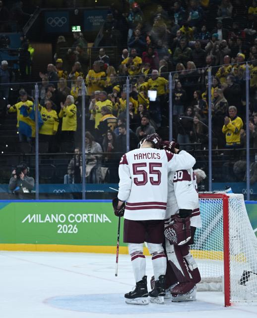 (260218) -- MILAN, Feb. 18, 2026 (Xinhua) -- Roberts Mamcics (L) and Elvis Merzlikins of Latvia react after the ice hockey men's qualification play-off match between the Sweden and Latvia at the Milan-Cortina 2026 Olympic Winter Games in Milan, Italy, Feb. 17, 2026. (Xinhua/Zhang Haofu)