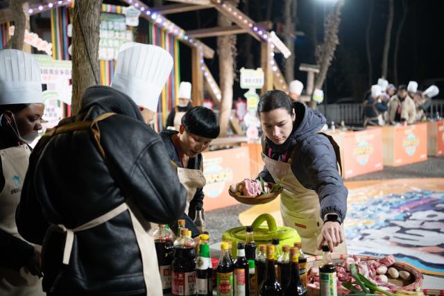 (260218) -- GUANGDE, Feb. 18, 2026 (Xinhua) -- Sasha (front, 1st R) attends a cooking competition in Dongting Town of Guangde City, east China's Anhui Province, Jan. 18, 2026. Sasha, an equestrian from Russia, once studied in Shanghai and later went to Europe to study equestrian sports, where she met coach Vasil and eventually married him. They have a lovely daughter named Maya. In 2023, Sasha's family moved to Guangde to start a new life, as her husband Vasil was invited to teach at the Yangtze River Delta International Equestrian Center.
  "Riding has always been my favorite," Sasha said in Chinese. Sasha's family now lives near the equestrian center, where she trains daily in equestrian show jumping, takes walks with her beloved horse, and sometimes helps with horse training. Looking ahead, she hopes to participate in more equestrian competitions and to one day own her own ranch.
  Beyond the racetrack, Sasha engages in cultural activities to learn about local customs and traditions. Her daughter Maya attends a local kindergarten and has learned Chinese. Her husband Vasil's equestrian teaching is well received by students. These experiences have helped Sasha feel a sense of belonging in a place once unfamiliar to her. "Guangde is picturesque and has friendly people. Living and training here makes me feel wonderful," said Sasha. (Xinhua/Zhang Duan)