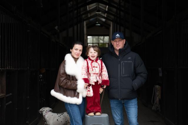 (260218) -- GUANGDE, Feb. 18, 2026 (Xinhua) -- Sasha poses for a photo with her husband Vasil and her daughter Maya at the entrance of a stable at the Yangtze River Delta International Equestrian Center in Dongting Town of Guangde City, east China's Anhui Province, Jan. 29, 2026. Sasha, an equestrian from Russia, once studied in Shanghai and later went to Europe to study equestrian sports, where she met coach Vasil and eventually married him. They have a lovely daughter named Maya. In 2023, Sasha's family moved to Guangde to start a new life, as her husband Vasil was invited to teach at the Yangtze River Delta International Equestrian Center.
  "Riding has always been my favorite," Sasha said in Chinese. Sasha's family now lives near the equestrian center, where she trains daily in equestrian show jumping, takes walks with her beloved horse, and sometimes helps with horse training. Looking ahead, she hopes to participate in more equestrian competitions and to one day own her own ranch.
  Beyond the racetrack, Sasha engages in cultural activities to learn about local customs and traditions. Her daughter Maya attends a local kindergarten and has learned Chinese. Her husband Vasil's equestrian teaching is well received by students. These experiences have helped Sasha feel a sense of belonging in a place once unfamiliar to her. "Guangde is picturesque and has friendly people. Living and training here makes me feel wonderful," said Sasha. (Xinhua/Zhang Duan)