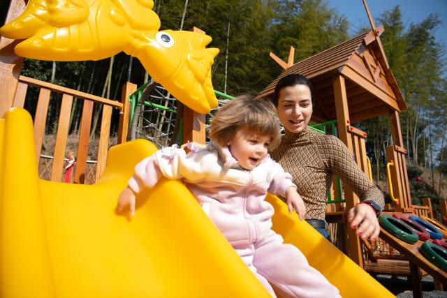 (260218) -- GUANGDE, Feb. 18, 2026 (Xinhua) -- Sasha accompanies her daughter Maya to play at a park in Dongting Town of Guangde City, east China's Anhui Province, Jan. 15, 2026. Sasha, an equestrian from Russia, once studied in Shanghai and later went to Europe to study equestrian sports, where she met coach Vasil and eventually married him. They have a lovely daughter named Maya. In 2023, Sasha's family moved to Guangde to start a new life, as her husband Vasil was invited to teach at the Yangtze River Delta International Equestrian Center.
  "Riding has always been my favorite," Sasha said in Chinese. Sasha's family now lives near the equestrian center, where she trains daily in equestrian show jumping, takes walks with her beloved horse, and sometimes helps with horse training. Looking ahead, she hopes to participate in more equestrian competitions and to one day own her own ranch.
  Beyond the racetrack, Sasha engages in cultural activities to learn about local customs and traditions. Her daughter Maya attends a local kindergarten and has learned Chinese. Her husband Vasil's equestrian teaching is well received by students. These experiences have helped Sasha feel a sense of belonging in a place once unfamiliar to her. "Guangde is picturesque and has friendly people. Living and training here makes me feel wonderful," said Sasha. (Xinhua/Zhang Duan)