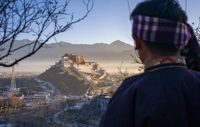 (260218) -- LHASA, Feb. 18, 2026 (Xinhua) -- A citizen looks at the Potala Palace in the distance in Lhasa, southwest China's Xizang Autonomous Region., Feb. 18, 2026. Wednesday marked the first day of the Tibetan New Year. (Xinhua/Tenzin Nyida)