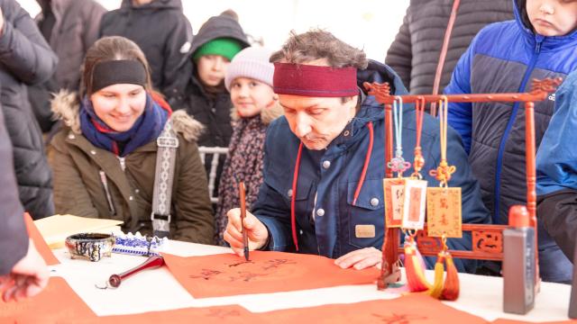 (260218) -- BELGRADE, Feb. 18, 2026 (Xinhua) -- A local visitor tries Chinese calligraphy during an event celebrating the Spring Festival in Belgrade, Serbia, Feb. 17, 2026. A series of events celebrating the Spring Festival were held here on Monday and Tuesday, creating a festive atmosphere and attracting thousands of local residents and members from the Chinese community. (Photo by Wang Wei/Xinhua)