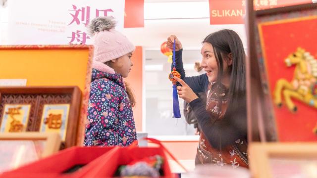 (260218) -- BELGRADE, Feb. 18, 2026 (Xinhua) -- A Chinese artist introduces Chinese intangible cultural heritage works to a girl during an event celebrating the Spring Festival in Belgrade, Serbia, Feb. 17, 2026. A series of events celebrating the Spring Festival were held here on Monday and Tuesday, creating a festive atmosphere and attracting thousands of local residents and members from the Chinese community. (Photo by Wang Wei/Xinhua)