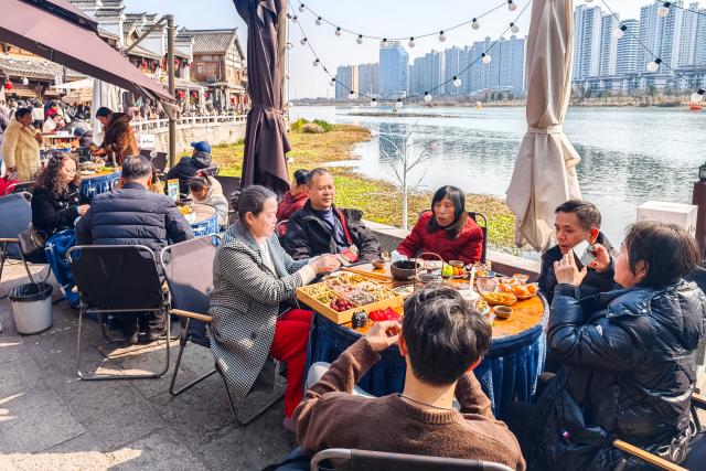 (260218) -- BEIJING, Feb. 18, 2026 (Xinhua) -- Tourists enjoy tea time at an outdoor tea house in Changde, central China's Hunan Province, Feb. 17, 2026. During this Spring Festival holiday, traditional Chinese New Year food and trendy cuisines have altogether become highlights for peoples' holiday consumption. (Xinhua/Chen Sihan)