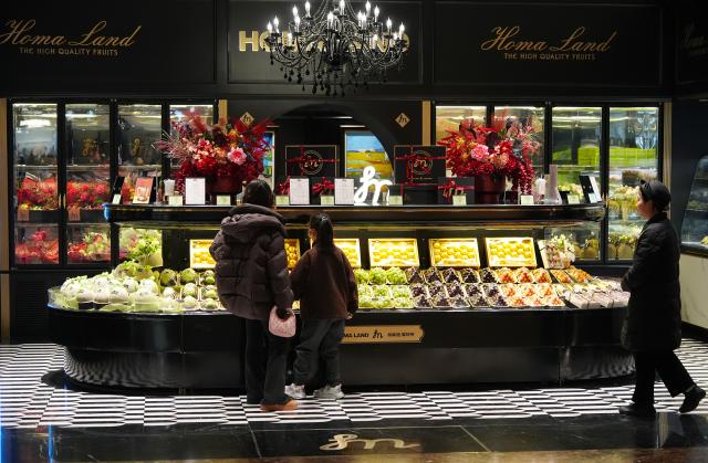 (260218) -- BEIJING, Feb. 18, 2026 (Xinhua) -- Customers buy fruits at a store in Xi'an, northwest China's Shaanxi Province, Feb. 17, 2026. During this Spring Festival holiday, traditional Chinese New Year food and trendy cuisines have altogether become highlights for peoples' holiday consumption. (Xinhua/Shao Rui)