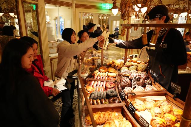 (260218) -- BEIJING, Feb. 18, 2026 (Xinhua) -- Customers buy breads at a bakery in Xi'an, northwest China's Shaanxi Province, Feb. 17, 2026. During this Spring Festival holiday, traditional Chinese New Year food and trendy cuisines have altogether become highlights for peoples' holiday consumption. (Xinhua/Shao Rui)