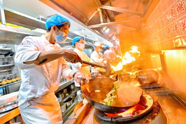 (260218) -- BEIJING, Feb. 18, 2026 (Xinhua) -- Chefs cook meals for customers at a restaurant in Binhai New Area of north China's Tianjin, Feb. 18, 2026. During this Spring Festival holiday, traditional Chinese New Year food and trendy cuisines have altogether become highlights for peoples' holiday consumption. (Photo by Du Penghui/Xinhua)