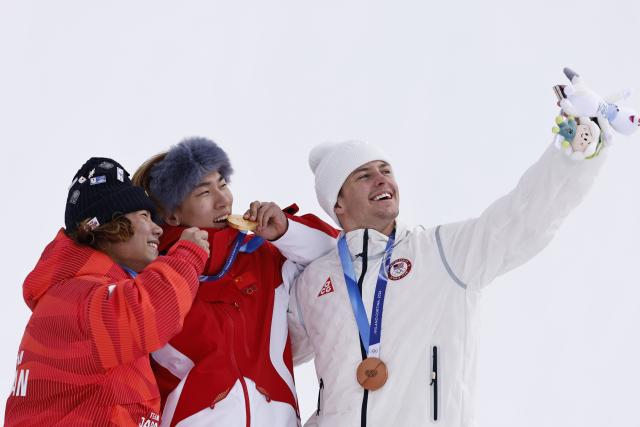 (260218) -- LIVIGNO, Feb. 18, 2026 (Xinhua) -- Gold medalist Su Yiming (C) of China, silver medalist Hasegawa Taiga (L) of Japan and bronze medalist Jake Canter of the United states pose for a selfie during the awarding ceremony for the snowboard men's slopestyle at the Milan-Cortina 2026 Olympic Winter Games in Livigno, Italy, Feb. 18, 2026. (Xinhua/Wang Peng)