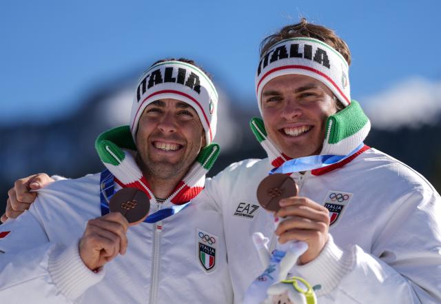 (260218) -- TESERO, Feb. 18, 2026 (Xinhua) -- Bronze medalists Elia Barp and Federico Pellegrino of Italy pose during the awarding ceremony for the cross-country skiing men's team sprint free at the Milan-Cortina 2026 Olympic Winter Games in Tesero, Italy, Feb. 18, 2026. (Xinhua/Peng Ziyang)