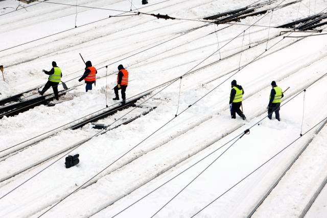 (260218) -- BUCHAREST, Feb. 18, 2026 (Xinhua) -- Workers clean snow at North Railway station in Bucharest, Romania, on Feb. 18, 2026. A heavy snowstorm hit southern and southeastern Romania overnight, prompting a red alert in Bucharest and disrupting road, air and maritime traffic, authorities said on Wednesday. (Photo by Cristian Cristel/Xinhua)