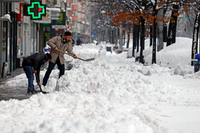 (260218) -- BUCHAREST, Feb. 18, 2026 (Xinhua) -- People shovel snow on a street in Bucharest, Romania, on Feb. 18, 2026. A heavy snowstorm hit southern and southeastern Romania overnight, prompting a red alert in Bucharest and disrupting road, air and maritime traffic, authorities said on Wednesday. (Photo by Cristian Cristel/Xinhua)