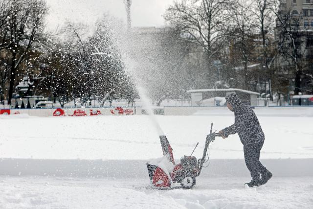 (260218) -- BUCHAREST, Feb. 18, 2026 (Xinhua) -- A worker cleans a snow-covered skating rink in a park in Bucharest, Romania, on Feb. 18, 2026. A heavy snowstorm hit southern and southeastern Romania overnight, prompting a red alert in Bucharest and disrupting road, air and maritime traffic, authorities said on Wednesday. (Photo by Cristian Cristel/Xinhua)