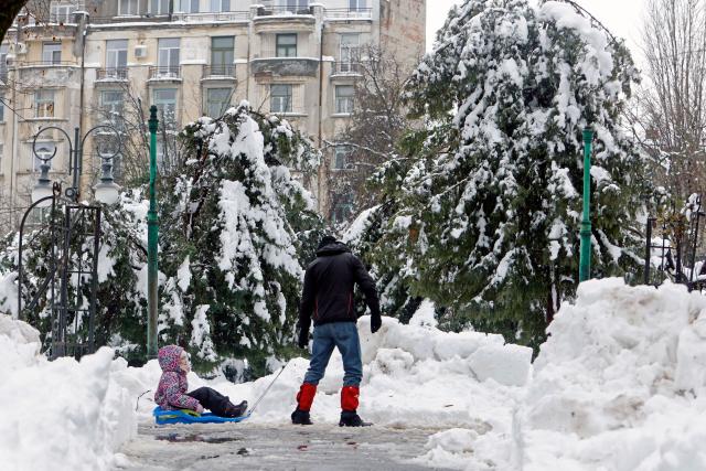 (260218) -- BUCHAREST, Feb. 18, 2026 (Xinhua) -- A man pulls a sledge in a snow-covered park in Bucharest, Romania, on Feb. 18, 2026. A heavy snowstorm hit southern and southeastern Romania overnight, prompting a red alert in Bucharest and disrupting road, air and maritime traffic, authorities said on Wednesday. (Photo by Cristian Cristel/Xinhua)