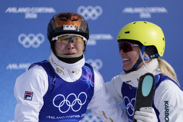 (260218) -- LIVIGNO, Feb. 18, 2026 (Xinhua) -- Xu Mengtao (L) of China and Danielle Scott of Australia react after the freestyle skiing women's aerials final 2 at the Milan-Cortina 2026 Olympic Winter Games in Livigno, Italy, Feb. 18, 2026. (Xinhua/Hu Chao)