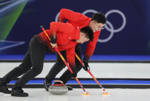 (260218) -- CORTINA D'AMPEZZO, Feb. 18, 2026 (Xinhua) -- Xu Jingtao (R) and Li Zhichao of China compete during the curling men's round robin session 11 match between the Czech Republic and China at the 2026 Milan-Cortina Winter Olympics in Cortina, Italy, Feb. 18, 2026. (Xinhua/Ding Xu)