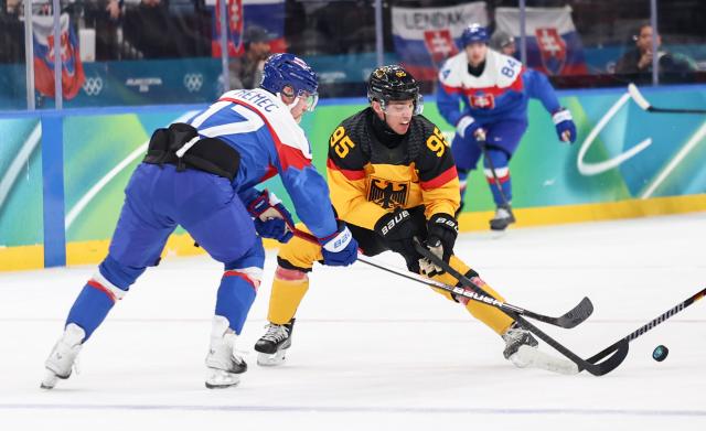 (260218) -- MILAN, Feb. 18, 2026 (Xinhua) -- Frederik Tiffels (R) of Germany vies with Simon Nemec of Slovakia during the ice hockey men's play-offs quarterfinal between the Slovakia and Germany at the Milan-Cortina 2026 Olympic Winter Games in Milan, Italy, Feb. 18, 2026. (Xinhua/Wang Kaiyan)