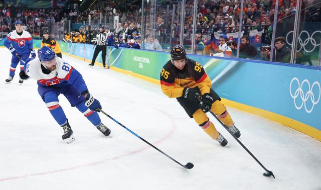 (260218) -- MILAN, Feb. 18, 2026 (Xinhua) -- Frederik Tiffels (R) of Germany vies with Erik Cernak of Slovakia during the ice hockey men's play-offs quarterfinal between the Slovakia and Germany at the Milan-Cortina 2026 Olympic Winter Games in Milan, Italy, Feb. 18, 2026. (Xinhua/Wang Kaiyan)