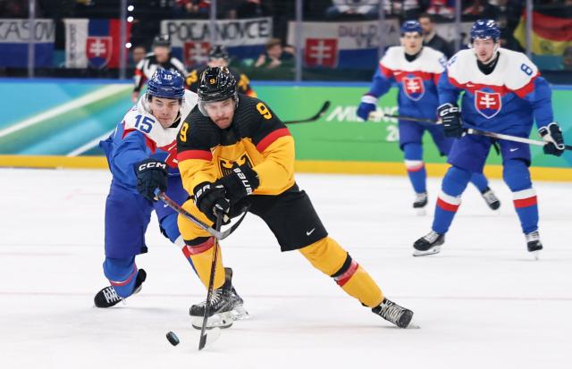 (260218) -- MILAN, Feb. 18, 2026 (Xinhua) -- Leon Gawanke (R, front) of Germany vies with Dalibor Dvorsky of Slovakia during the ice hockey men's play-offs quarterfinal between the Slovakia and Germany at the Milan-Cortina 2026 Olympic Winter Games in Milan, Italy, Feb. 18, 2026. (Xinhua/Wang Kaiyan)