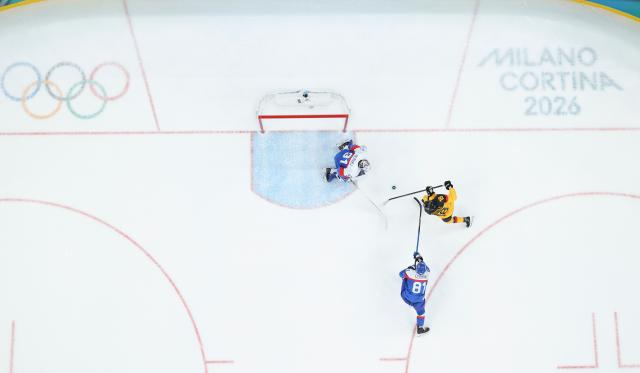 (260218) -- MILAN, Feb. 18, 2026 (Xinhua) -- Tim Stutzle (R) of Germany scores during the ice hockey men's play-offs quarterfinal between the Slovakia and Germany at the Milan-Cortina 2026 Olympic Winter Games in Milan, Italy, Feb. 18, 2026. (Xinhua/Wang Kaiyan)