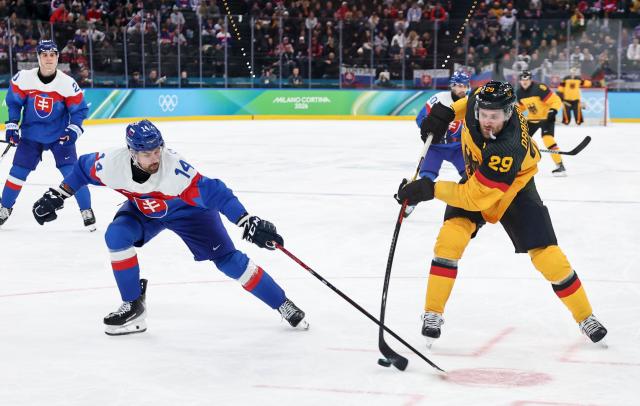 (260218) -- MILAN, Feb. 18, 2026 (Xinhua) -- Leon Draisaitl (R) of Germany shoots during the ice hockey men's play-offs quarterfinal between the Slovakia and Germany at the Milan-Cortina 2026 Olympic Winter Games in Milan, Italy, Feb. 18, 2026. (Xinhua/Wang Kaiyan)