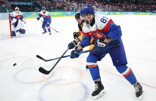 (260218) -- MILAN, Feb. 18, 2026 (Xinhua) -- Erik Cernak (front) of Slovakia competes during the ice hockey men's play-offs quarterfinal between the Slovakia and Germany at the Milan-Cortina 2026 Olympic Winter Games in Milan, Italy, Feb. 18, 2026. (Xinhua/Wang Kaiyan)