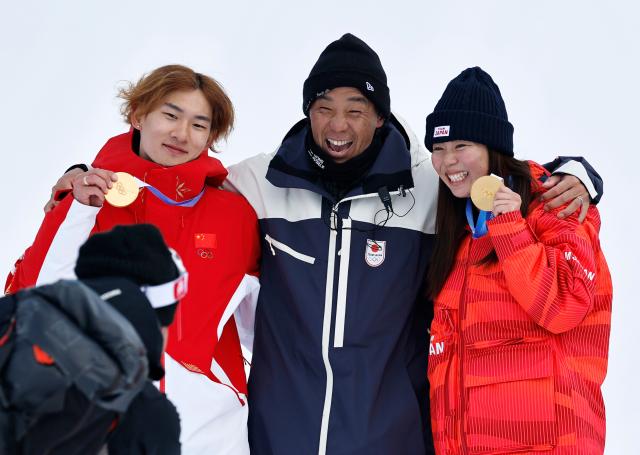 (260218) -- LIVIGNO, Feb. 18, 2026 (Xinhua) -- Fukada Mari (R) of Japan and Su Yiming (L) of China pose for photos after the snowboard women's slopestyle final at the Milan-Cortina 2026 Olympic Winter Games in Livigno, Italy, Feb. 18, 2026. (Xinhua/Wang Peng)