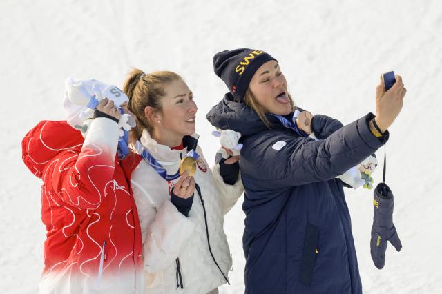 (260218) -- CORTINA D'AMPEZZO, Feb. 18, 2026 (Xinhua) -- Gold medalist Mikaela Shiffrin (C) of the United States, silver medalist Camille Rast (L) of Switzerland, and bronze medalist Anna Swenn Larsson of Sweden take a selfie during the awarding ceremony of the alpine skiing women's slalom at the Milan-Cortina 2026 Olympic Winter Games in Cortina, Italy, Feb. 18, 2026. (Xinhua/Fei Maohua)