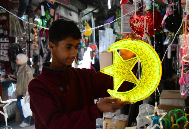 (260218) -- DAMASCUS, Feb. 18, 2026 (Xinhua) -- A young man looks at Ramadan-themed decorations in the old quarter of Damascus, Syria, on Feb. 18, 2026. (Photo by Ammar Safarjalani/Xinhua)