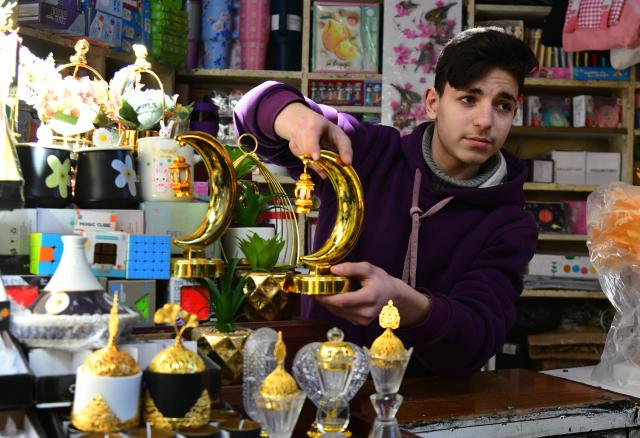 (260218) -- DAMASCUS, Feb. 18, 2026 (Xinhua) -- A young man displays Ramadan-themed decorations in the old quarter of Damascus, Syria, on Feb. 18, 2026.