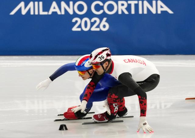 (260218) -- MILAN, Feb. 18, 2026 (Xinhua) -- Pietro Sighel (L) of Italy and Maxime Laoun of Canada compete during the short track speed skating men's 500m semifinal at the Milan-Cortina 2026 Olympic Winter Games in Milan, Italy, Feb. 18, 2026. (Xinhua/Lai Xiangdong)