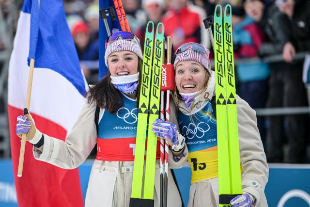(260219) -- ANTERSELVA, Feb. 19, 2026 (Xinhua) -- Camille Bened (L) and Oceane Michelon of France celebrate after the biathlon women's 4x6km relay at the 2026 Milan-Cortina Winter Olympics in Anterselva, Italy, Feb. 18, 2026. (Xinhua/Jiang Han)