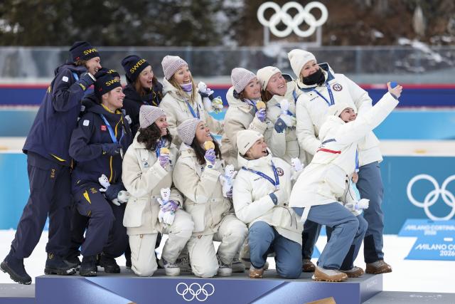 (260219) -- ANTERSELVA, Feb. 19, 2026 (Xinhua) -- Gold medalists Team France (C), silver medalists Team Sweden (L) and bronze medalists Team Norway pose for selfies during the awarding ceremony for the biathlon women's 4x6km relay at the 2026 Milan-Cortina Winter Olympics in Anterselva, Italy, Feb. 18, 2026. (Xinhua/Zhang Tao)