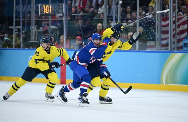 (260219) -- MILAN, Feb. 19, 2026 (Xinhua) -- Vincent Trocheck (C) of the United States fights for the puck against Adrian Kempe (R) of Sweden during the ice hockey men's play-offs quarterfinal between Sweden and the United States at the Milan-Cortina 2026 Olympic Winter Games in Milan, Italy, Feb. 18, 2026. (Xinhua/Zhang Haofu)