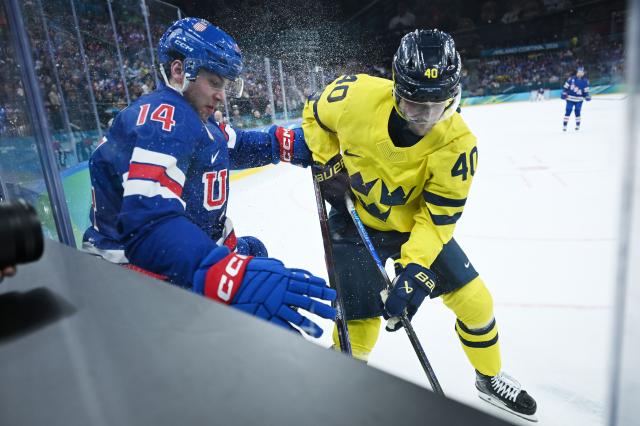 (260219) -- MILAN, Feb. 19, 2026 (Xinhua) -- Sweden's Elias Pettersson (R) fights for the puck against Brock Faber of the United States during the ice hockey men's play-offs quarterfinal between Sweden and the United States at the Milan-Cortina 2026 Olympic Winter Games in Milan, Italy, Feb. 18, 2026. (Xinhua/Zhang Haofu)
