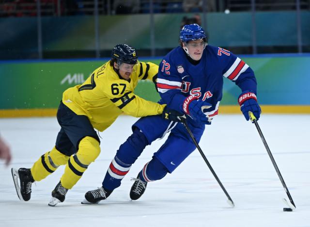 (260219) -- MILAN, Feb. 19, 2026 (Xinhua) -- Tage Thompson (R) of the United States fights for the puck against Rickard Rakell of Sweden during the ice hockey men's play-offs quarterfinal between Sweden and the United States at the Milan-Cortina 2026 Olympic Winter Games in Milan, Italy, Feb. 18, 2026. (Xinhua/Zhang Haofu)