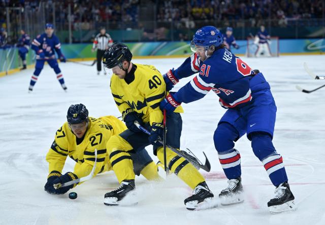 (260219) -- MILAN, Feb. 19, 2026 (Xinhua) -- Elias Pettersson (C) of Sweden fights for the puck against Clayton Keller (R) of the United States during the ice hockey men's play-offs quarterfinal between Sweden and the United States at the Milan-Cortina 2026 Olympic Winter Games in Milan, Italy, Feb. 18, 2026. (Xinhua/Zhang Haofu)